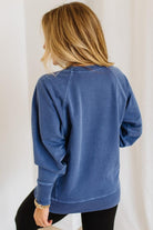Person wearing a blue sweatshirt with a plain background