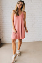 Blonde woman wearing a knee length ribbed kit dress.