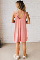 Blonde woman wearing a knee length ribbed kit dress.