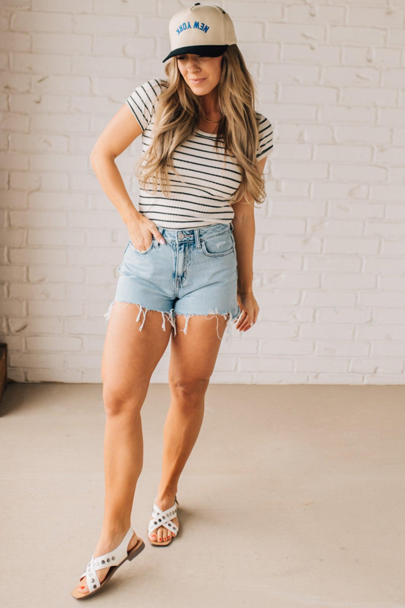 Blonde woman wearing a scoop neck, slim fit tee with vertical ribbed pattern, and horizontal printed stripes.