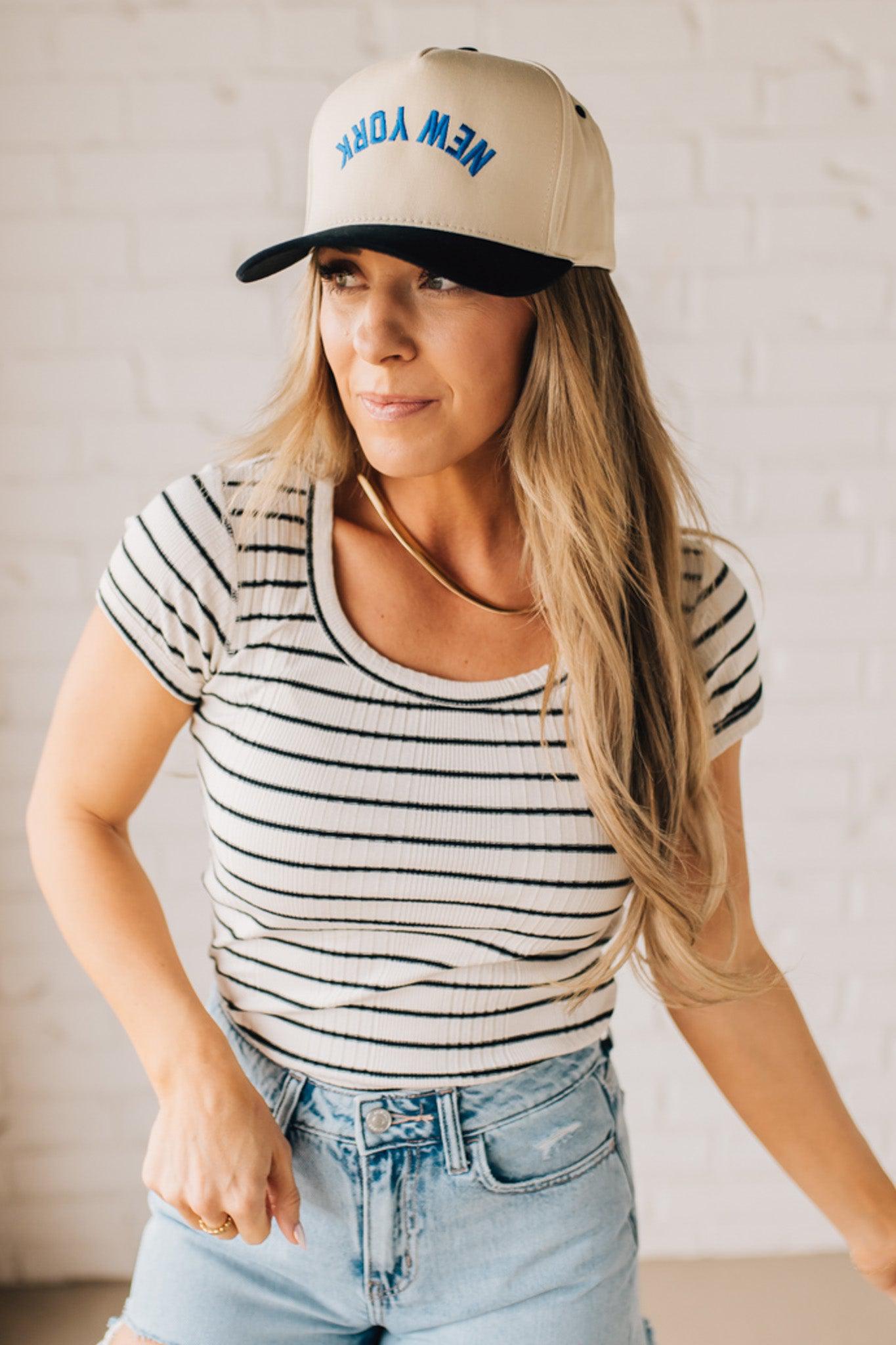 Blonde woman wearing a scoop neck, slim fit tee with vertical ribbed pattern, and horizontal printed stripes.