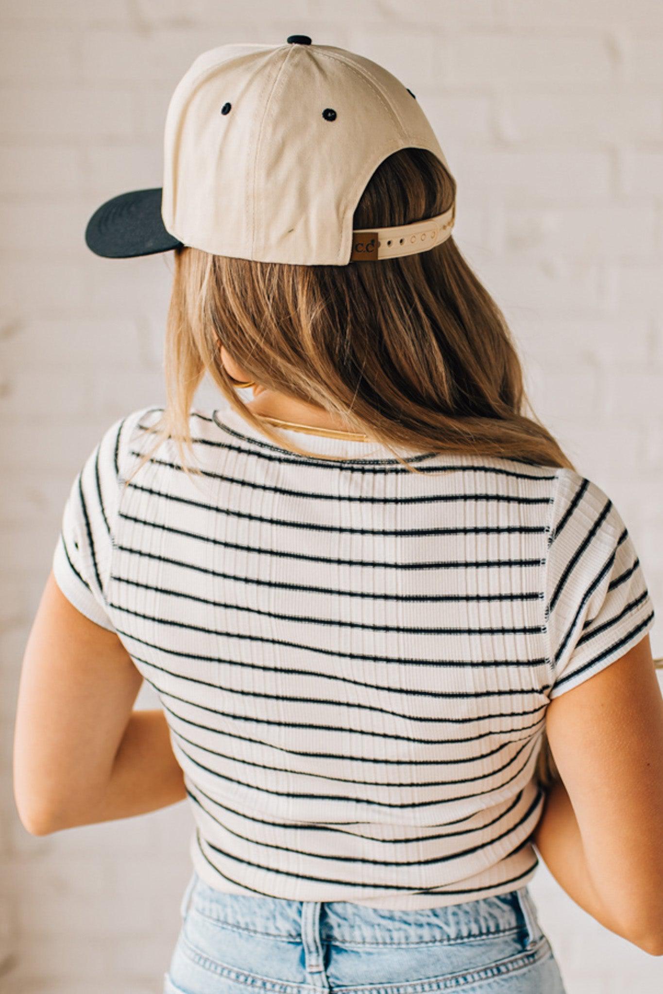 Blonde woman wearing a scoop neck, slim fit tee with vertical ribbed pattern, and horizontal printed stripes.