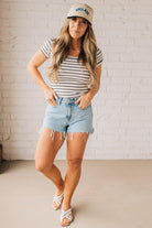 Blonde woman wearing a scoop neck, slim fit tee with vertical ribbed pattern, and horizontal printed stripes.