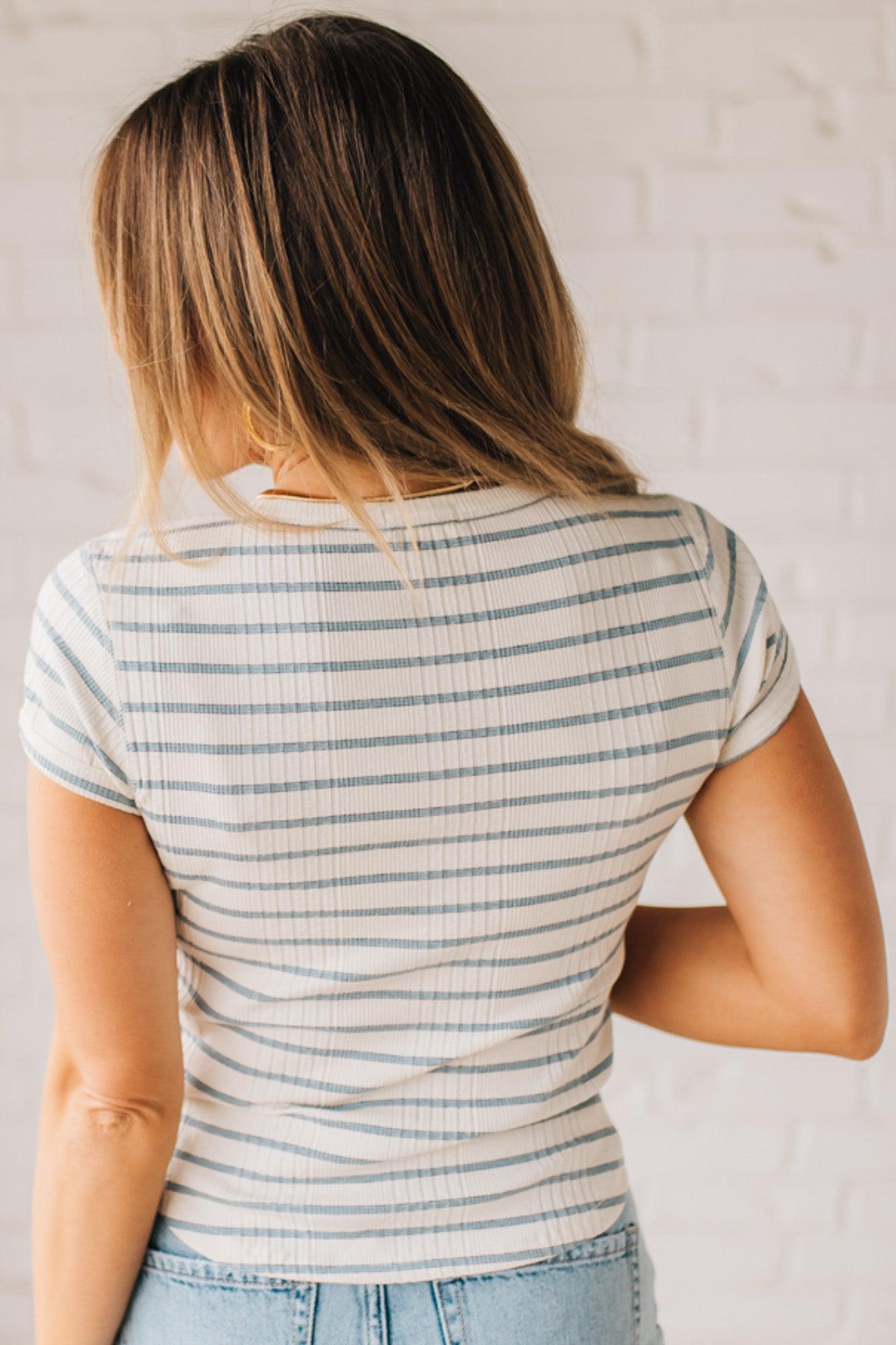 Blonde woman wearing a scoop neck, slim fit tee with vertical ribbed pattern, and horizontal printed stripes.