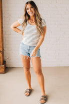 Blonde woman wearing a scoop neck, slim fit tee with vertical ribbed pattern, and horizontal printed stripes.