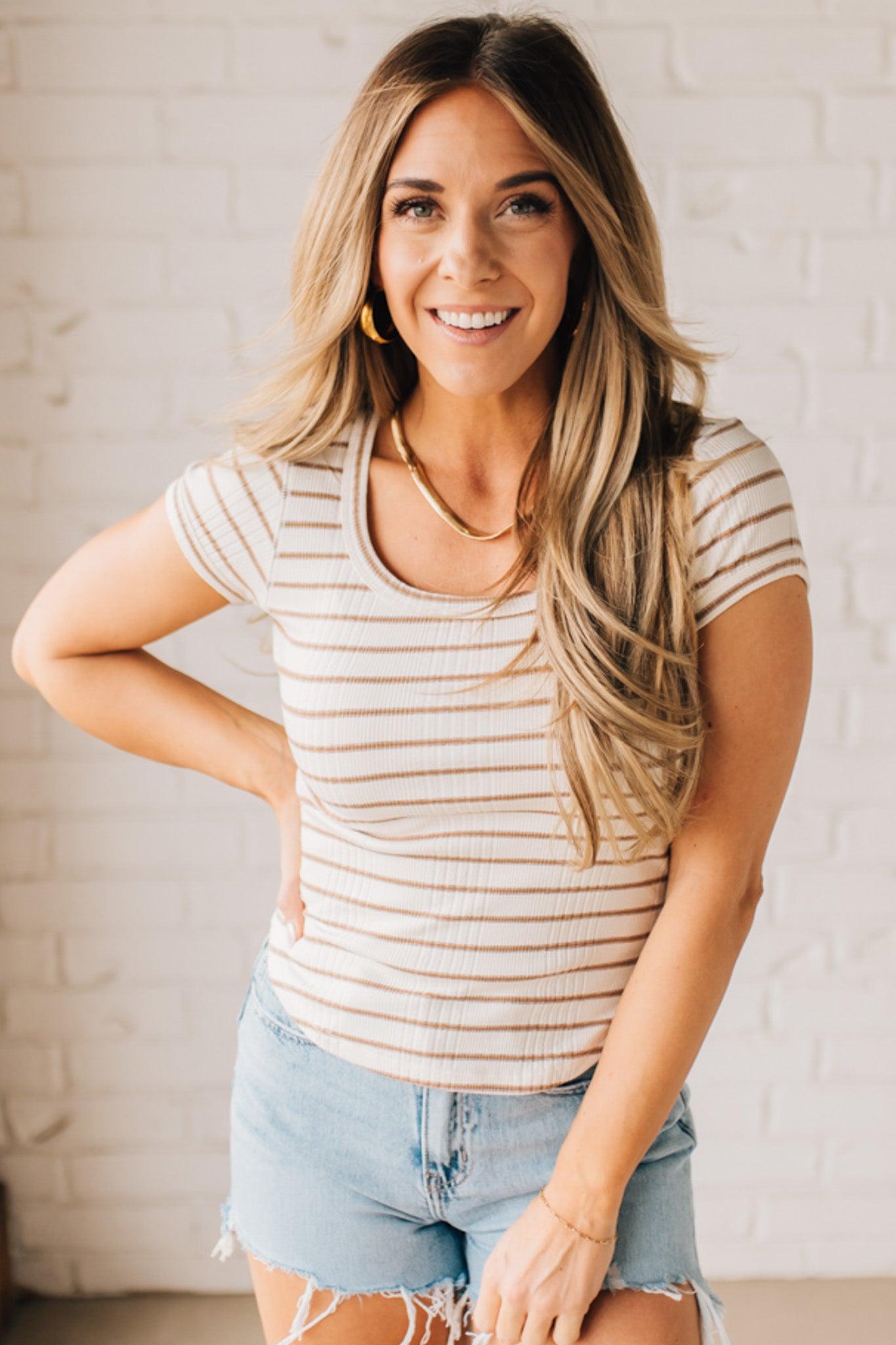 Blonde woman wearing a scoop neck, slim fit tee with vertical ribbed pattern, and horizontal printed stripes.