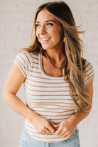 Blonde woman wearing a scoop neck, slim fit tee with vertical ribbed pattern, and horizontal printed stripes.