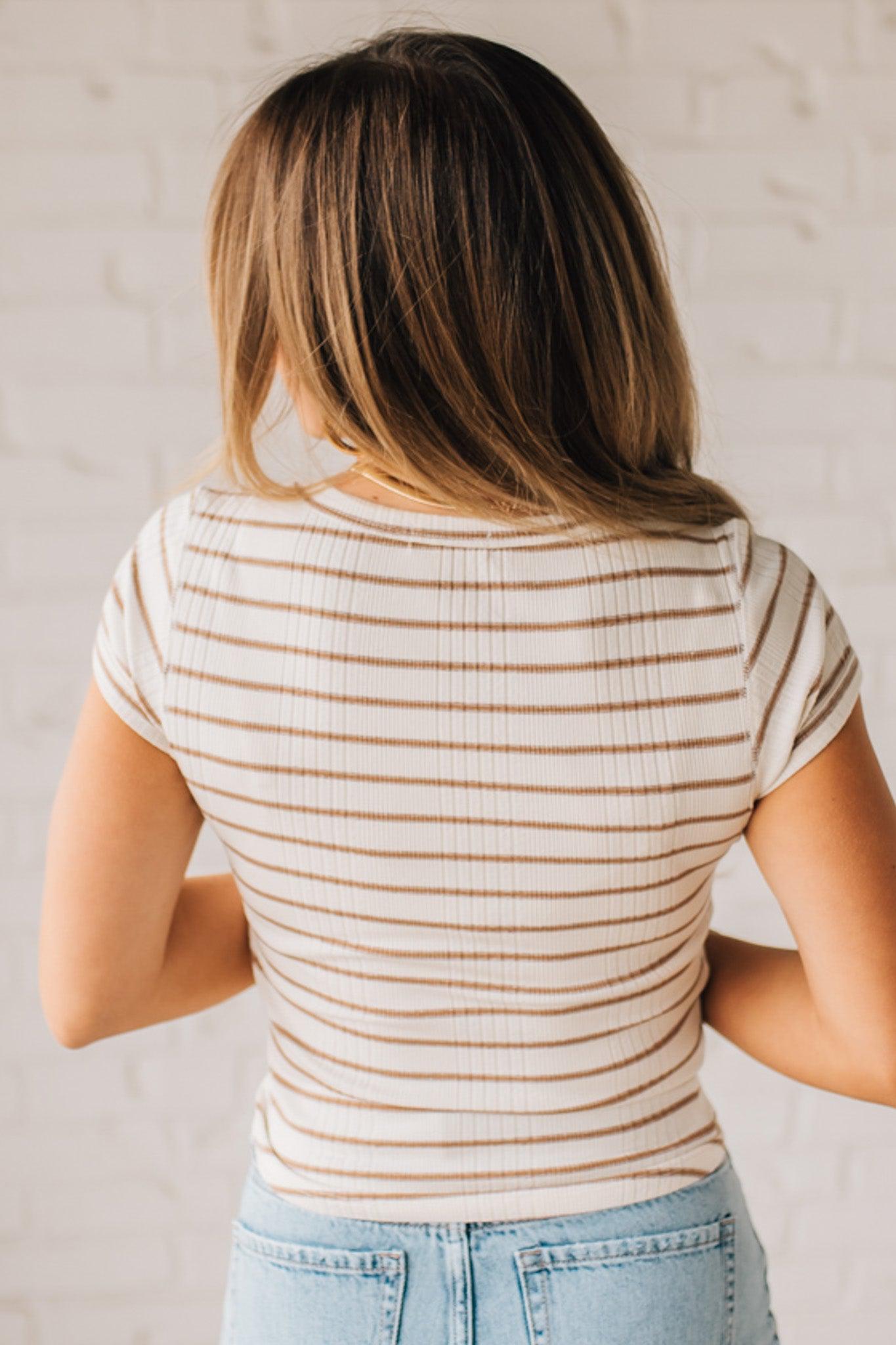 Blonde woman wearing a scoop neck, slim fit tee with vertical ribbed pattern, and horizontal printed stripes.