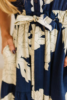 Close-up of a navy and white floral dress with a belt.