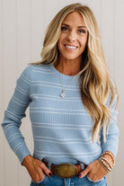 BLONDE WOMAN IN A STUDIO WEARING JEANS AND A BIG BELT WITH A BLUE RIBBED, LONG SLEEVE, CREW NECK, SUPER STRETCHY BASIC STRIPED INNER SWEATER.