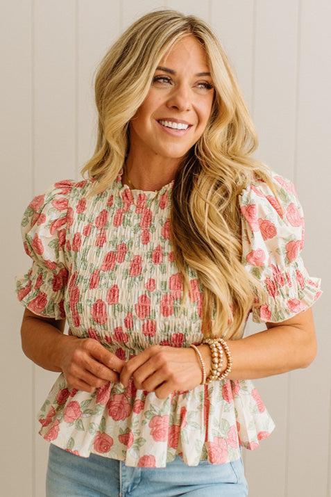 Woman wearing a floral blouse with a neutral background