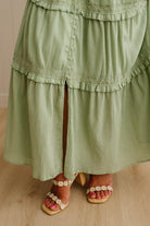 Green layered dress with lace details on a neutral background