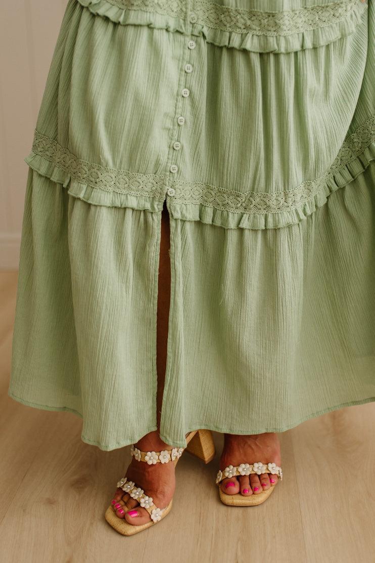 Green layered dress with lace details on a neutral background