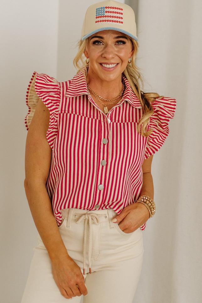 Woman wearing a red and white striped shirt with ruffled sleeves and a matching cap.