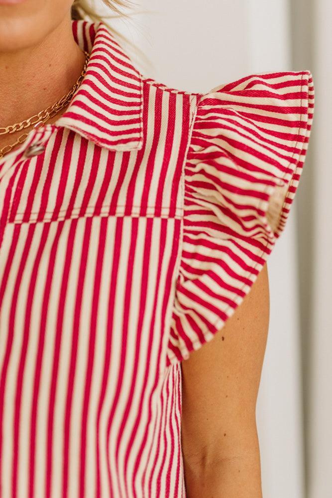 Red and white striped top with ruffled collar on a person against a neutral background