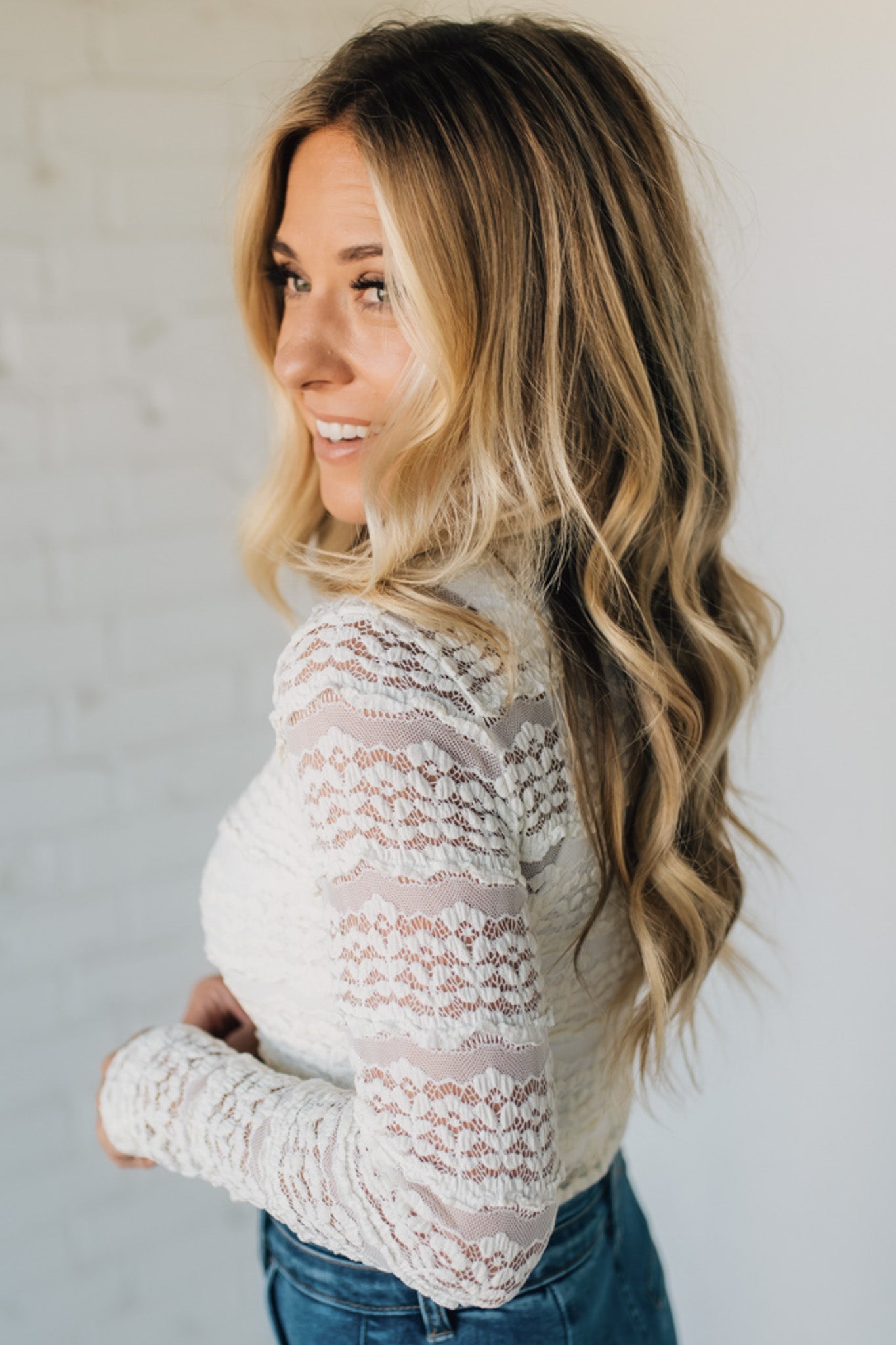 Woman wearing a lace top with a plain background