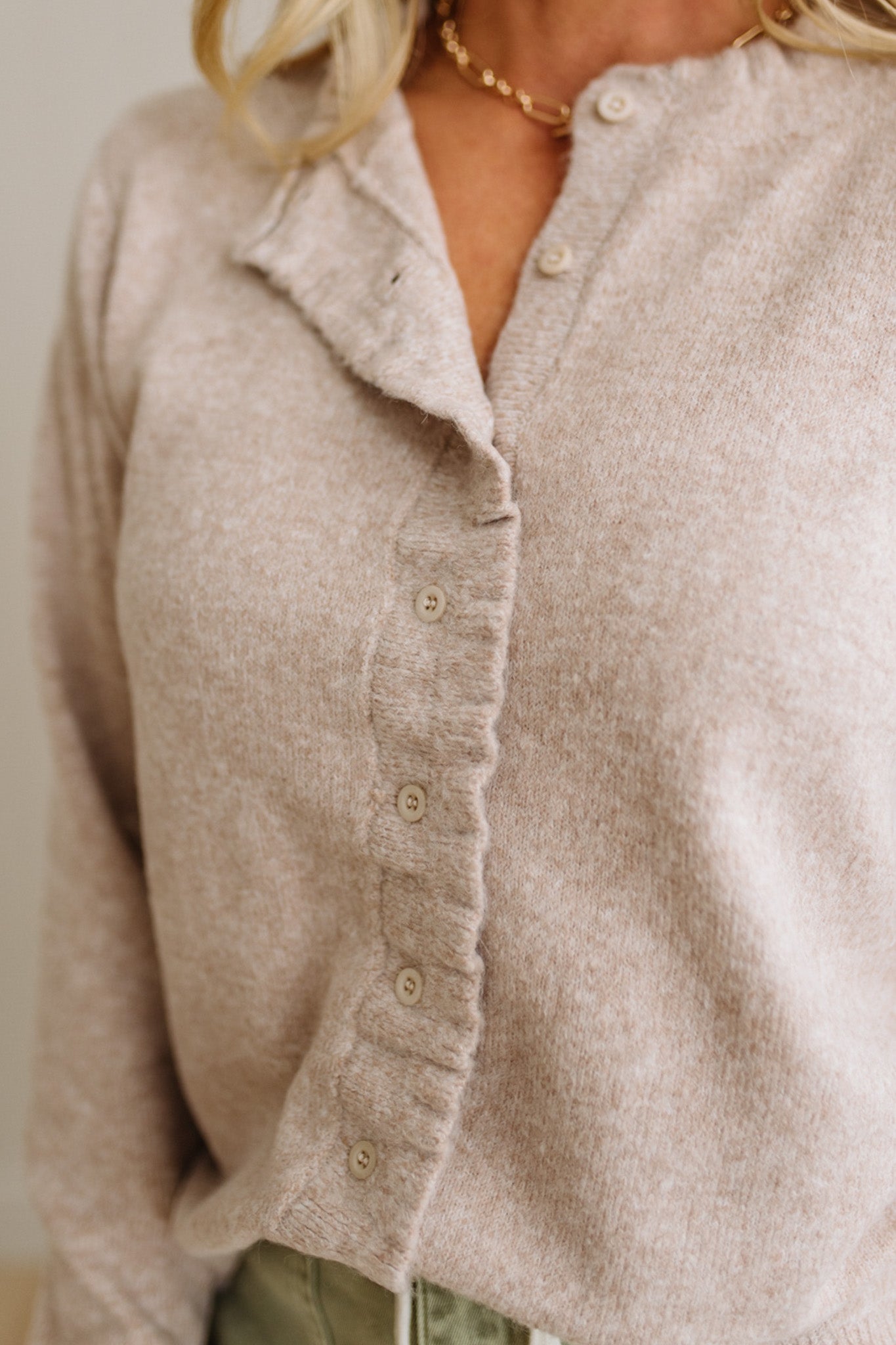 Close-up of a beige button-up shirt worn by a person.
