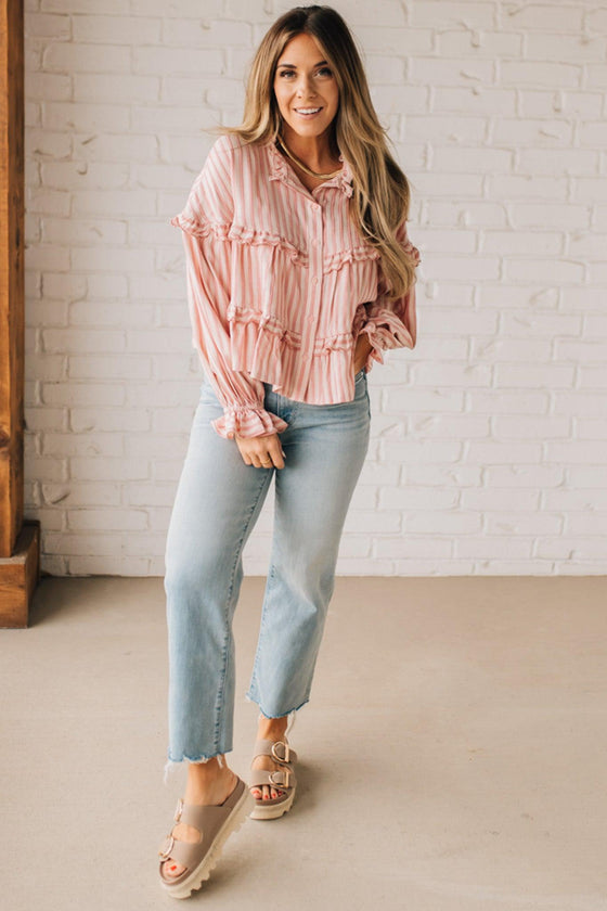 BLONDE WOMAN WEARING A VARIEGATED STRIPE FLOWY BOHO TOP WITH BUTTONED PLACKET.