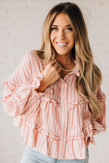  BLONDE WOMAN WEARING A VARIEGATED STRIPE FLOWY BOHO TOP WITH BUTTONED PLACKET.