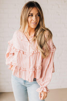 BLONDE WOMAN WEARING A VARIEGATED STRIPE FLOWY BOHO TOP WITH BUTTONED PLACKET.