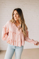 BLONDE WOMAN WEARING A VARIEGATED STRIPE FLOWY BOHO TOP WITH BUTTONED PLACKET.