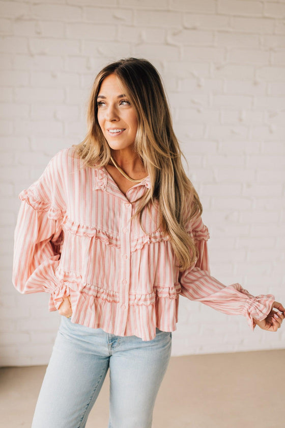 BLONDE WOMAN WEARING A VARIEGATED STRIPE FLOWY BOHO TOP WITH BUTTONED PLACKET.