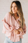 BLONDE WOMAN WEARING A VARIEGATED STRIPE FLOWY BOHO TOP WITH BUTTONED PLACKET.