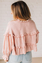 BLONDE WOMAN WEARING A VARIEGATED STRIPE FLOWY BOHO TOP WITH BUTTONED PLACKET.