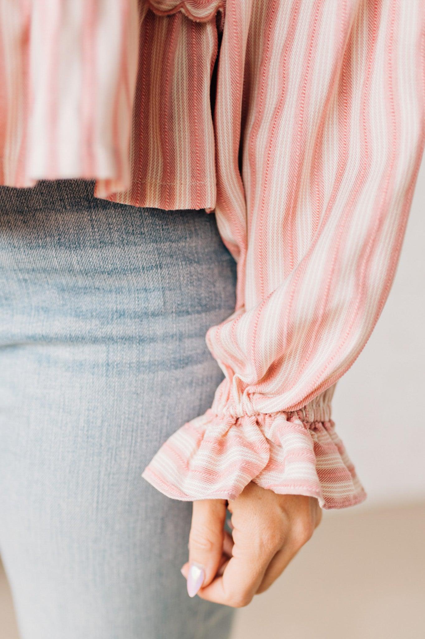 BLONDE WOMAN WEARING A VARIEGATED STRIPE FLOWY BOHO TOP WITH BUTTONED PLACKET.