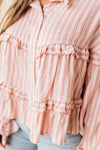 BLONDE WOMAN WEARING A VARIEGATED STRIPE FLOWY BOHO TOP WITH BUTTONED PLACKET.