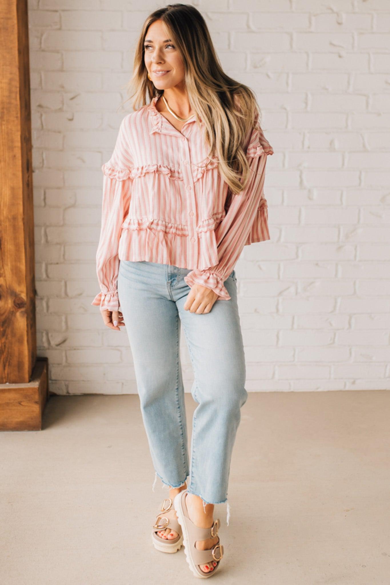 BLONDE WOMAN WEARING A VARIEGATED STRIPE FLOWY BOHO TOP WITH BUTTONED PLACKET.