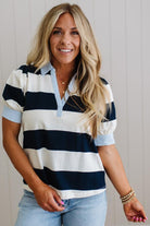 Woman wearing a navy and white striped shirt with a plain background