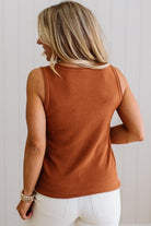 Woman wearing a rust-colored sleeveless top against a light background