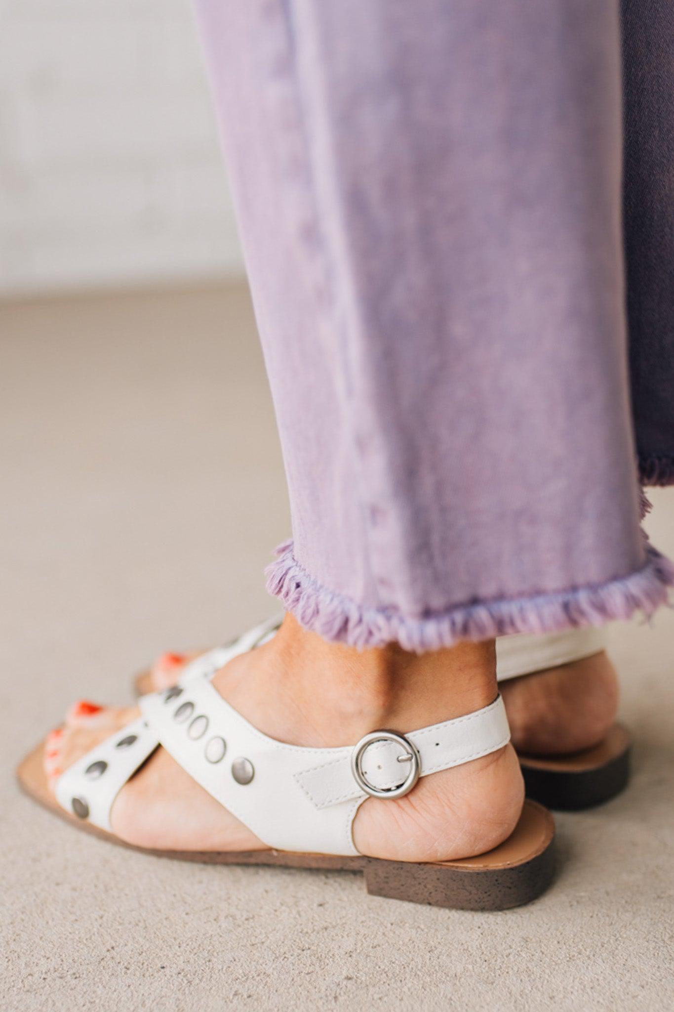 White faux leather sandals with features of metal studded embellishments on both straps, and a square cut toe.