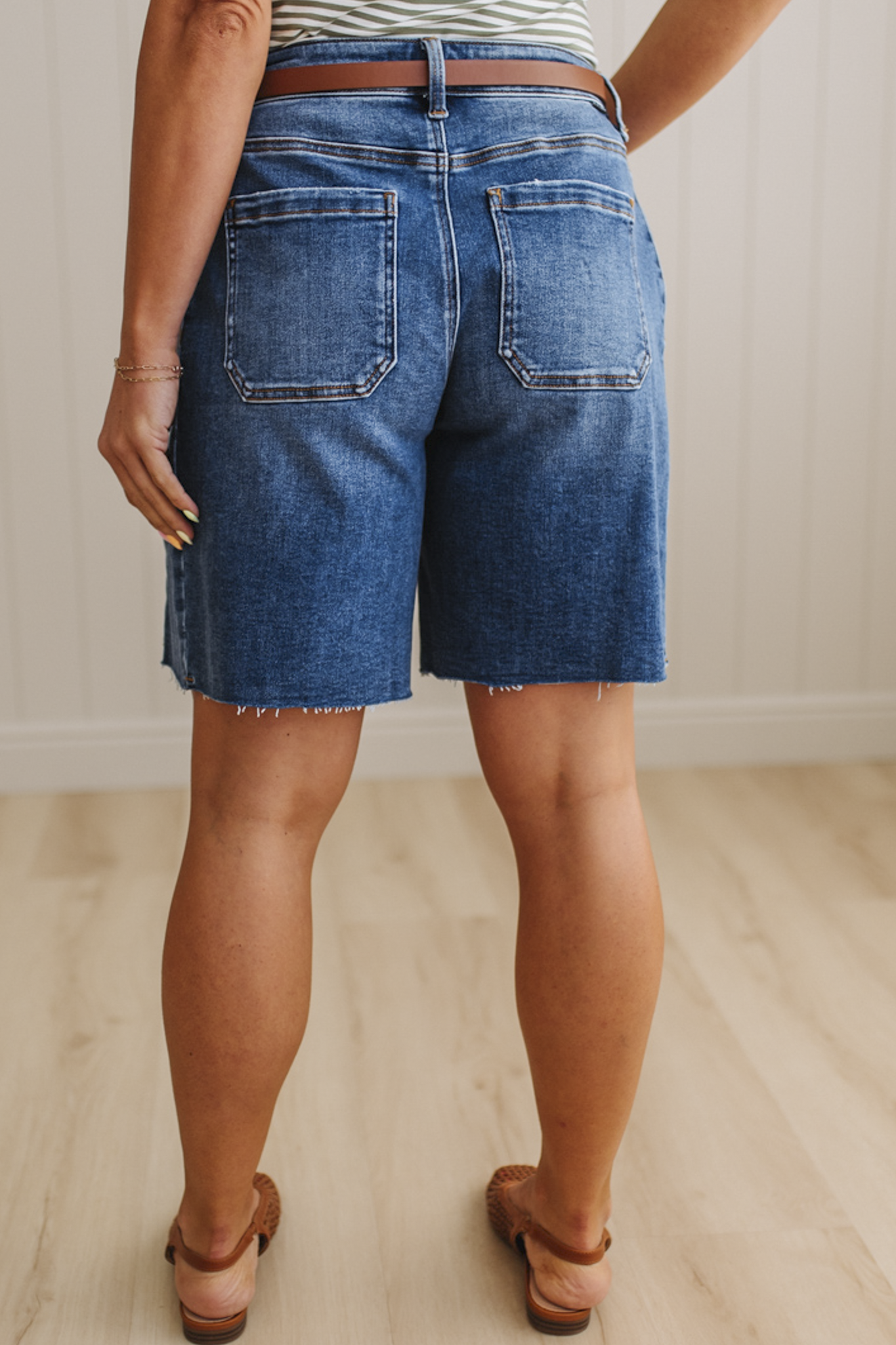 Person wearing blue denim shorts on a neutral background