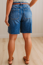 Person wearing blue denim shorts on a neutral background