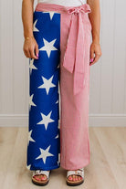 Person wearing a red, white, and blue outfit with star patterned pants and striped top.