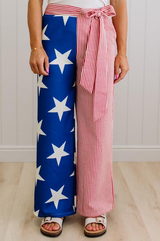 Person wearing a red, white, and blue outfit with star patterned pants and striped top.