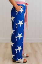 Person wearing a blue and white star-patterned pant leg, with another leg that is red and white striped. 