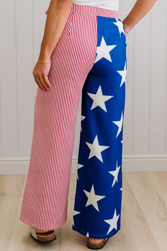 Person wearing a blue and white star-patterned pant leg, with another leg that is red and white striped. 