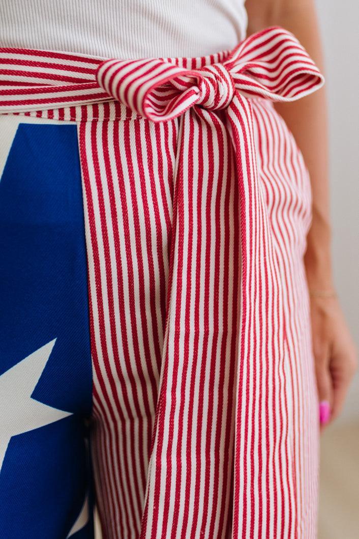Person wearing a red and white striped apron with a blue and white star design.