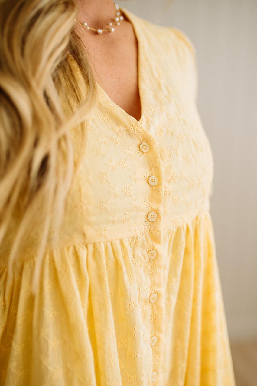 Yellow dress with buttons on a neutral background
