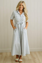 Blonde Woman Wearing a Striped Cotton Button Down Maxi Dress in Light Blue and White Fine Stripes
