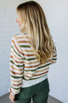 Woman wearing a striped sweater with a neutral background