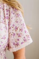 Floral-patterned fabric with purple flowers on a white background