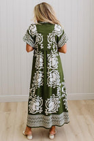 Woman wearing a green dress with white patterns in a minimal indoor setting