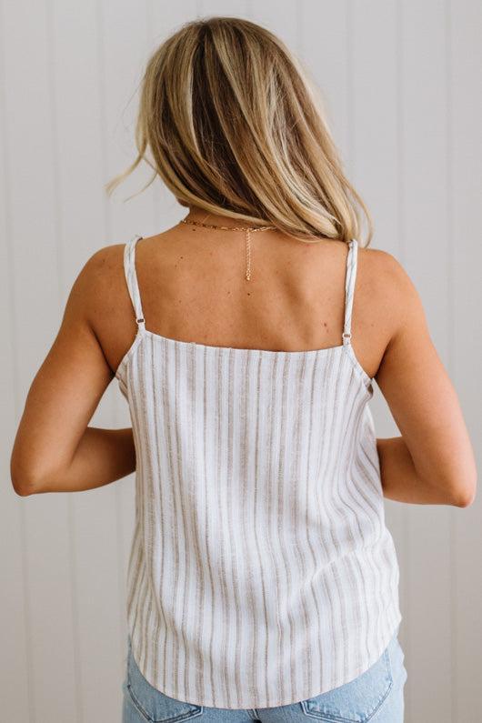 Woman wearing a striped tank top with a neutral background
