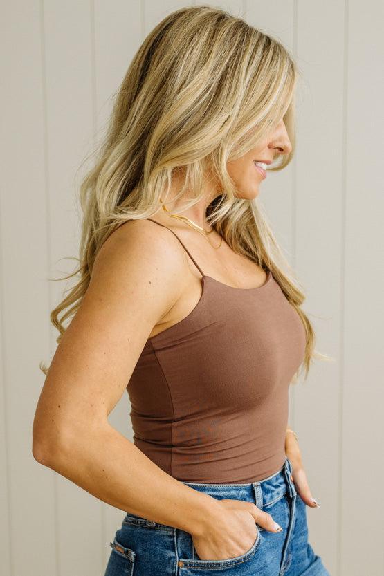 Blonde woman in jeans wearing a basic solid cami in brown.