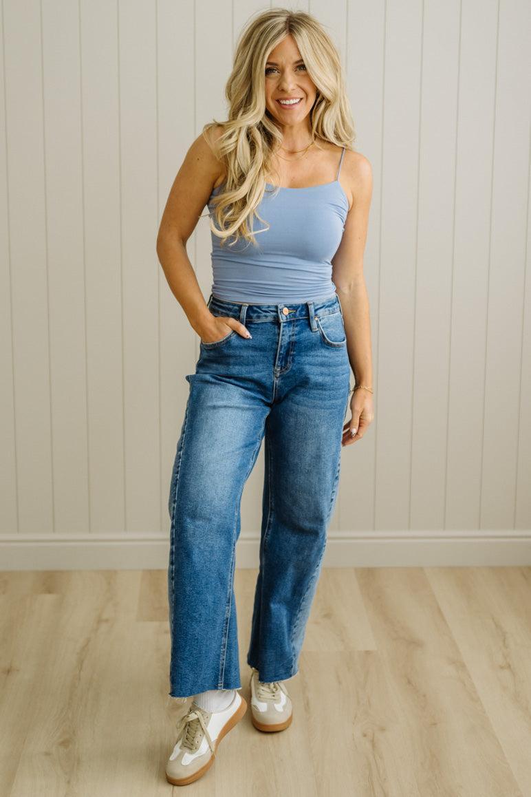 Blonde woman in jeans wearing a basic solid cami in blue.