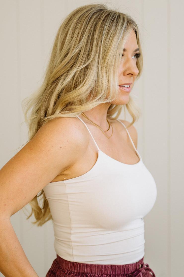 Blonde woman in jeans wearing a basic solid cami in ecru cream.